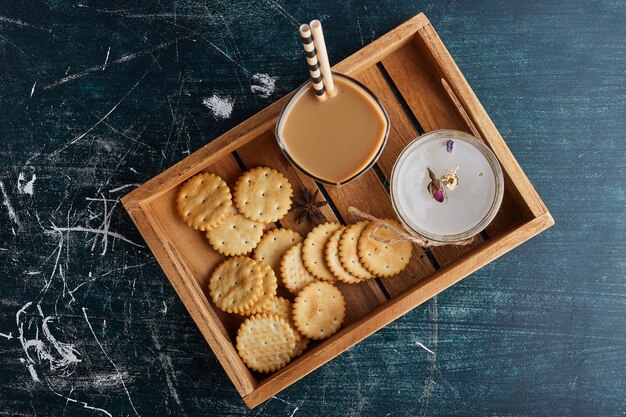 Una taza de café con galletas alrededor.