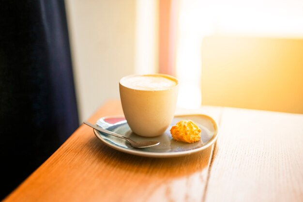 Taza de café y galletas en la mesa de madera