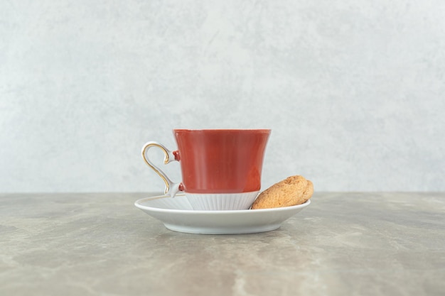 Taza de café con galletas en la mesa de mármol.