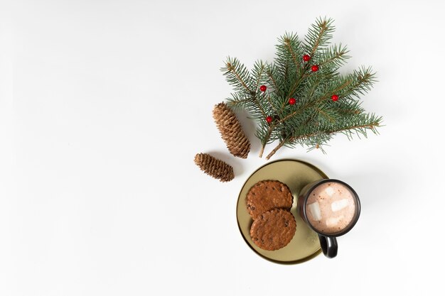 Taza de café con galletas y rama de abeto