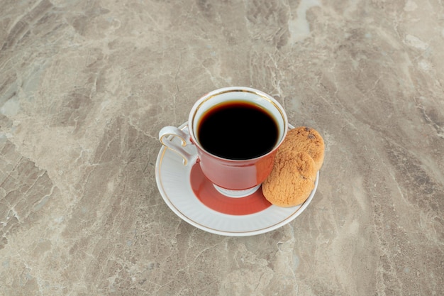 Taza de café con galletas en la superficie de mármol