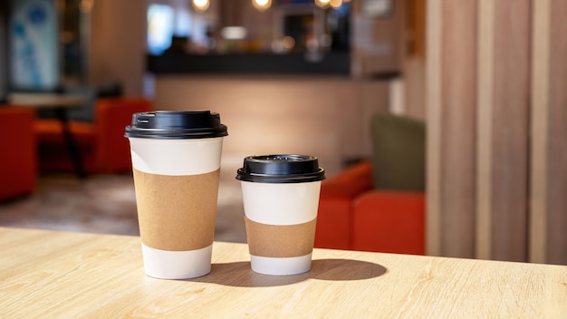 Foto gratuita taza de café grande y pequeña en una mesa de madera en un café. idea de reciclaje