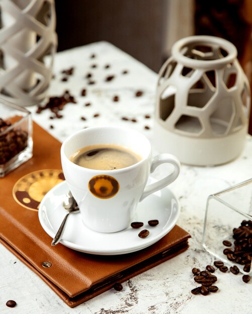 Una taza de café y granos de café.