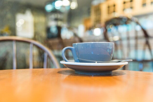 Taza de café gris en la mesa de madera