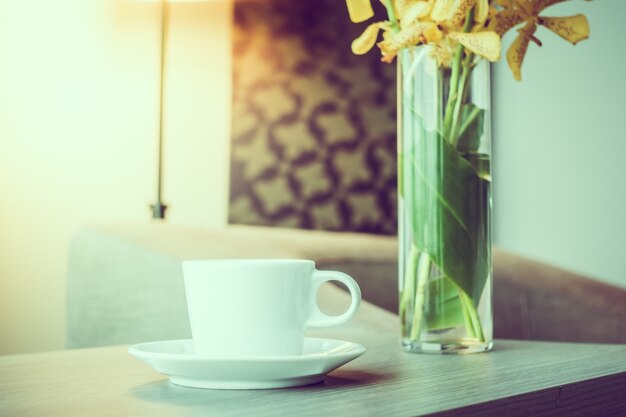 Taza de café junto a un jarrón