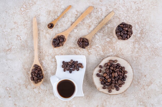 Una taza de café junto a varios pequeños paquetes de granos de café.