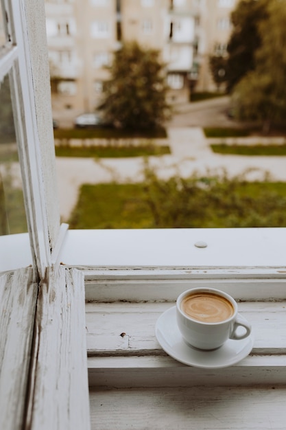 Foto gratuita una taza de café junto a la ventana.