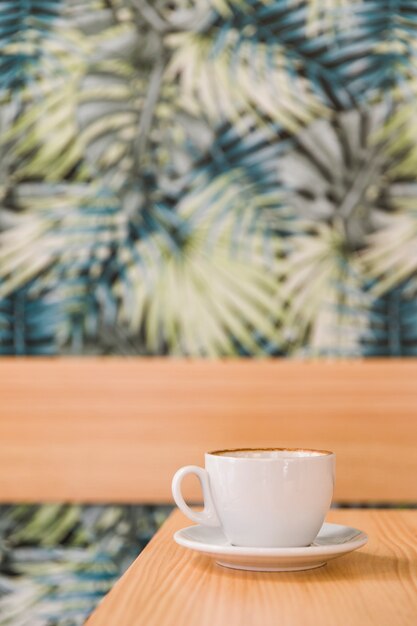 Taza de café con leche en el escritorio de madera