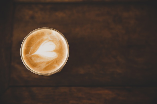 Taza de café con leche en la mesa de madera en cafetería cafetería