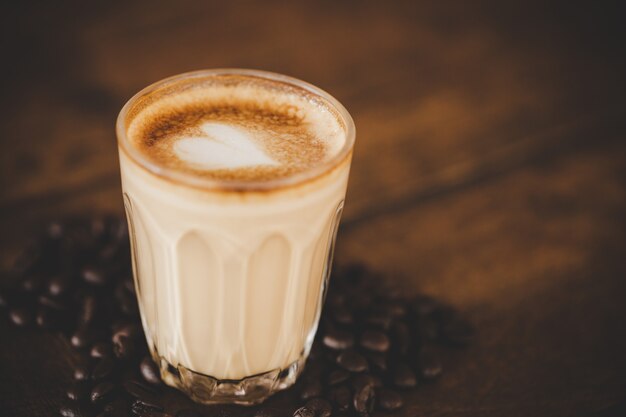 Taza de café con leche en la mesa de madera en cafetería cafetería