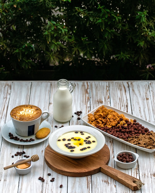 Una taza de café con leche y postre.