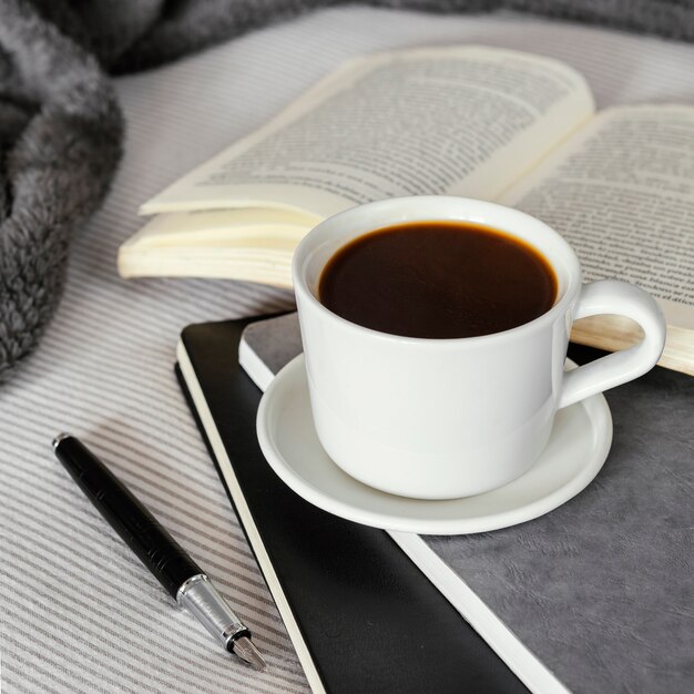 Taza de café y libro de ángulo alto