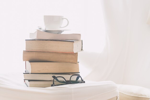 Taza de café con libro y gafas.