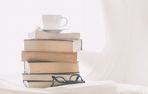 Taza de café con libro y gafas.