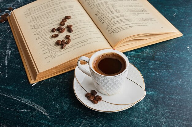 Una taza de café con un libro.