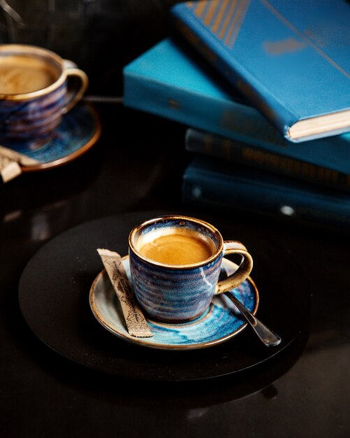 Una taza de café con libros sobre la mesa