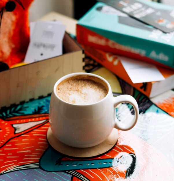 Una taza de café con libros sobre la mesa