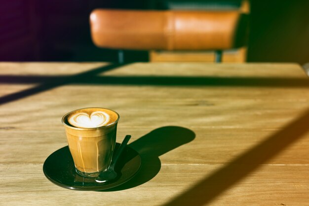 Taza de café en la mesa de madera con estilo de gradiente de foto