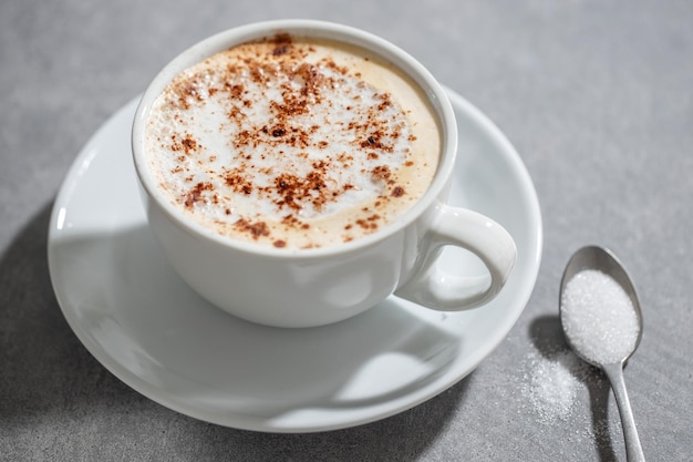 Taza de café en la mesa sobre fondo gris