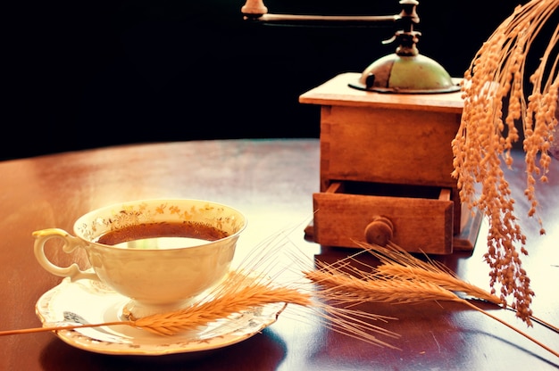 Taza de café con un molinillo antiguo