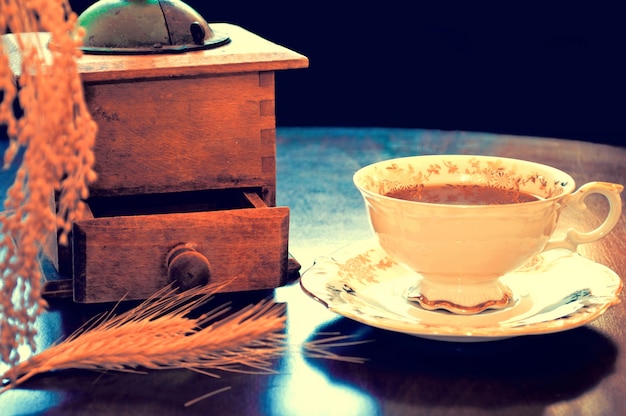 Foto gratuita taza de café con un molinillo antiguo