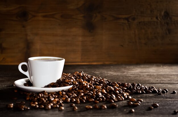 Taza de café con un montón de granos de café