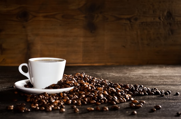 Taza de café con un montón de granos de café