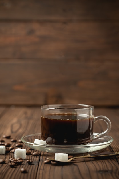 Taza de café negro en la mesa de madera.