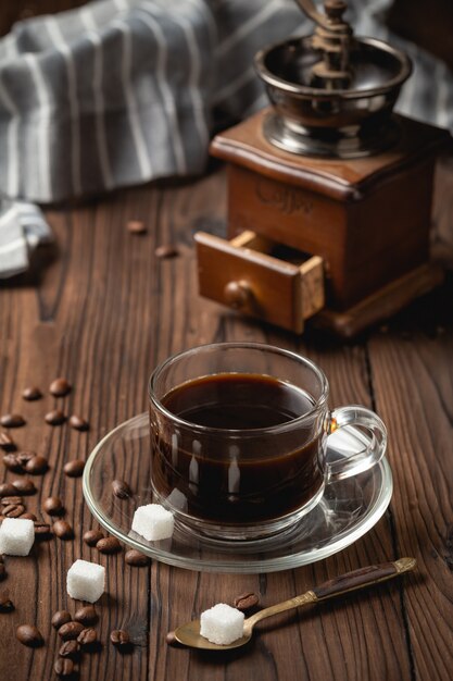 Taza de café negro en la mesa de madera.