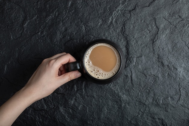 Foto gratuita una taza de café negro sobre negro.