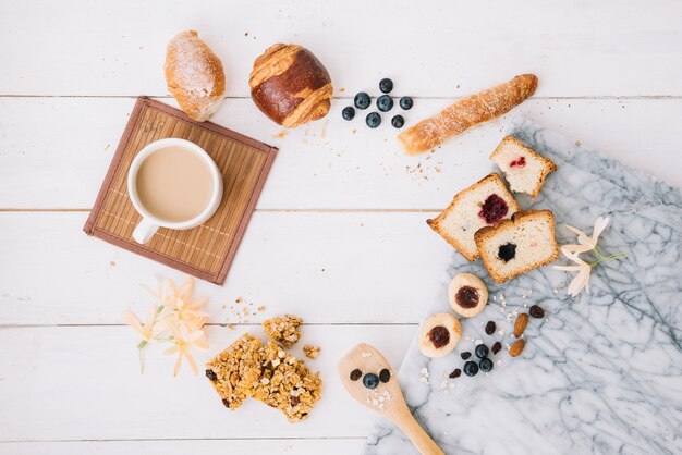 Taza de café con panadería en mesa de madera