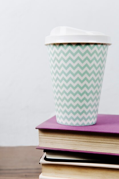 Taza de café en la pila de libros.