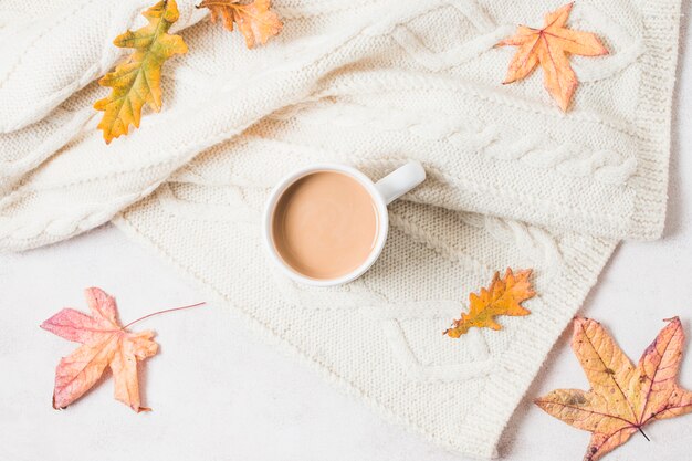 Taza de café plano en suéter acogedor.