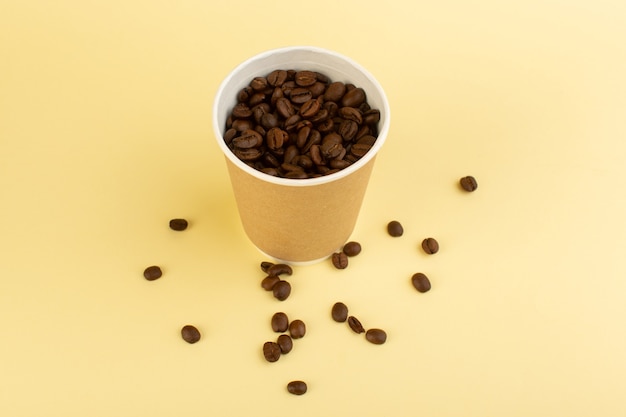 Una taza de café de plástico de vista superior con semillas de café marrón