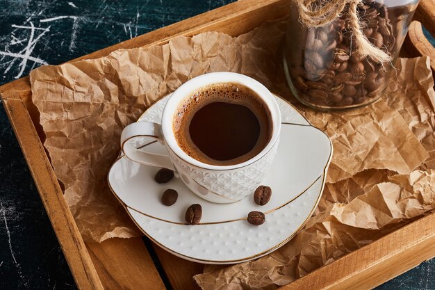 Una taza de café en platillo blanco.