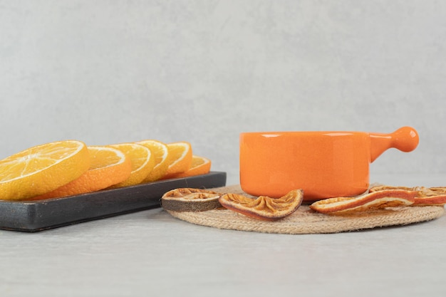 Taza de café y plato de rodajas de naranja.