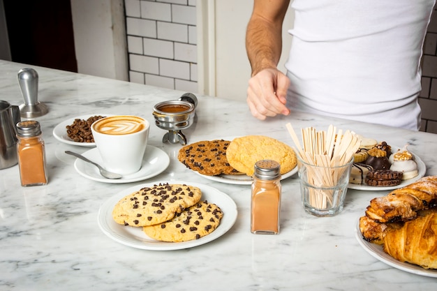 Taza de café y platos de galletas en el mostrador