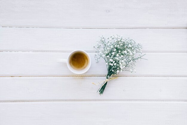 Taza de café y ramo de flores