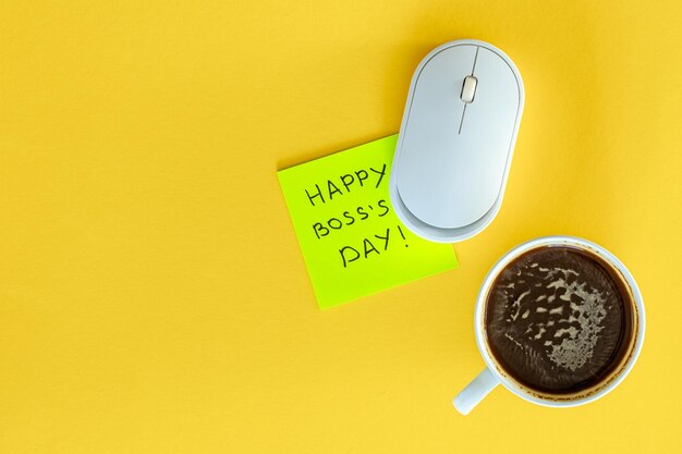 Una taza de café un ratón de computadora y la inscripción feliz día del jefe