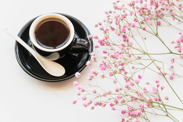 Taza de café recién hecho con flores rosas