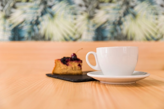 Taza de café con repostería en la superficie de madera