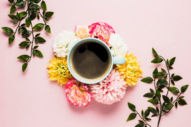 Taza de café rodeada de flores