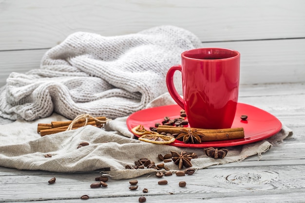 Taza de café roja en un plato, pared de madera, bebida