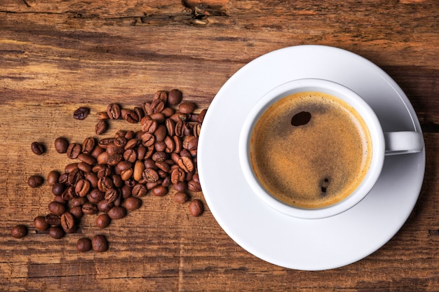 Taza de café sobre una mesa de madera. Fondo oscuro