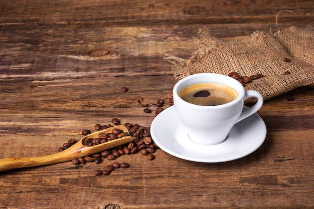 Taza de café sobre una mesa de madera. Fondo oscuro