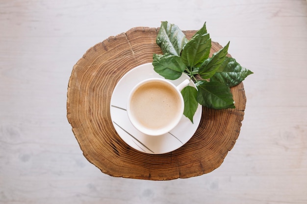 Foto gratuita taza de café en el tablero de madera con hojas