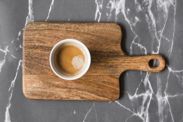 Taza de café en tajadera sobre fondo de mármol gris