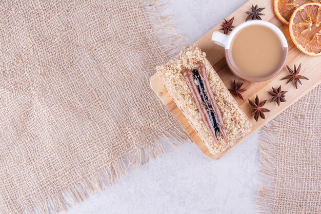 Taza de café, tarta y rodajas de naranja sobre tabla de madera. Foto de alta calidad