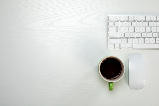 Una taza de café y teclado y mouse inalámbricos