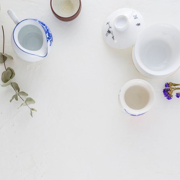 Taza de café tradicional blanco y azul y tetera sobre fondo blanco